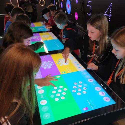 Schülerinnen spielen am großen Tablet