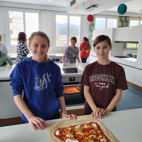 Schülerinnen vor der zubereiteten Pizza.