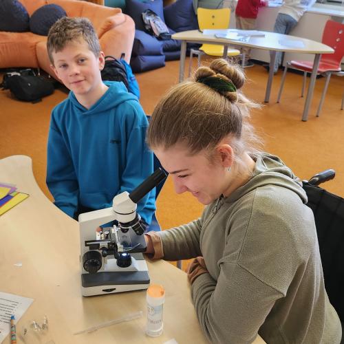 Schülerin arbeitet mit dem Mikroskop.