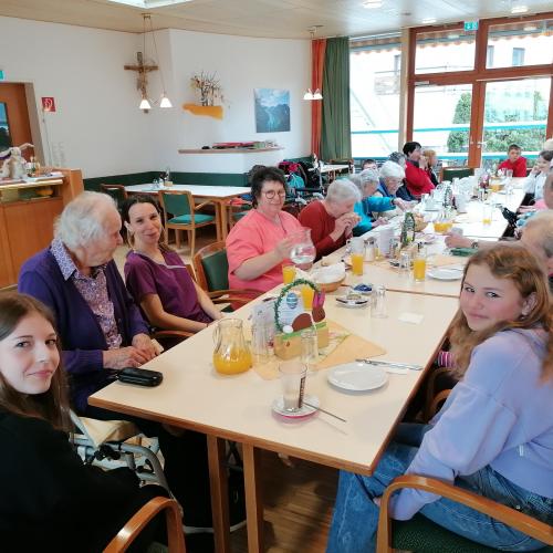Schülerinnen beim Essen mit de Bewohnern des Altersheims.