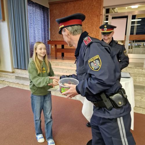 Die Polizei gibt einer Schülerin der 3a ihren Preis.